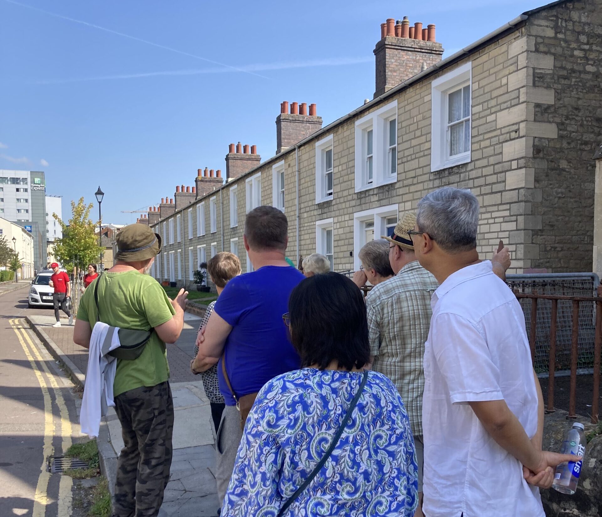 A guide leads a group of tourists through the streets of Swindon Railway Village.