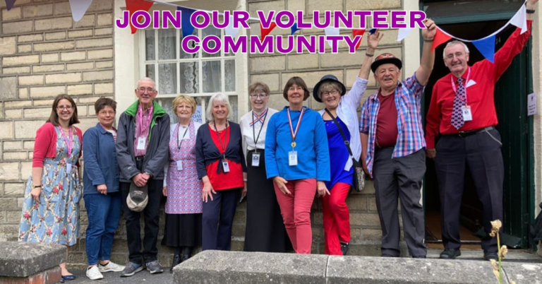 A group of volunteer standing outside the railway village museum, with the text above them "Join our volunteer community!".